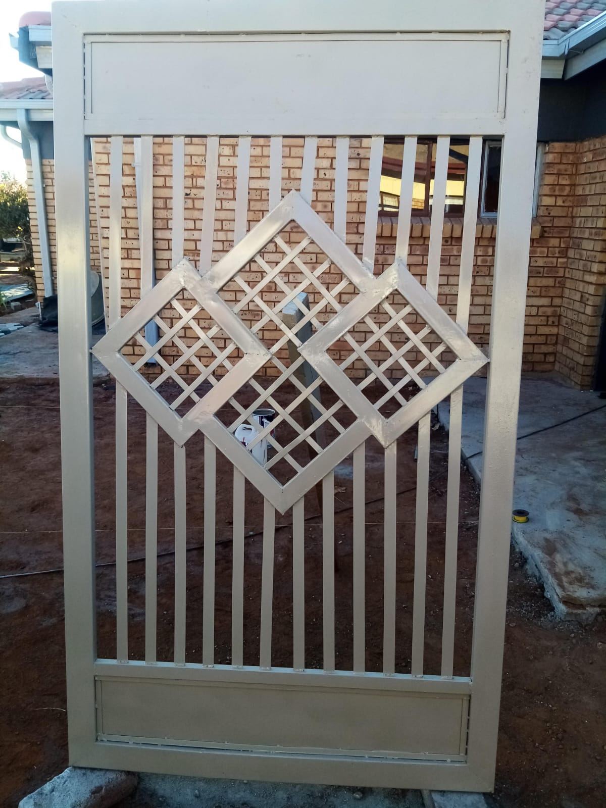 Cream sliding gate with a custom steel infill