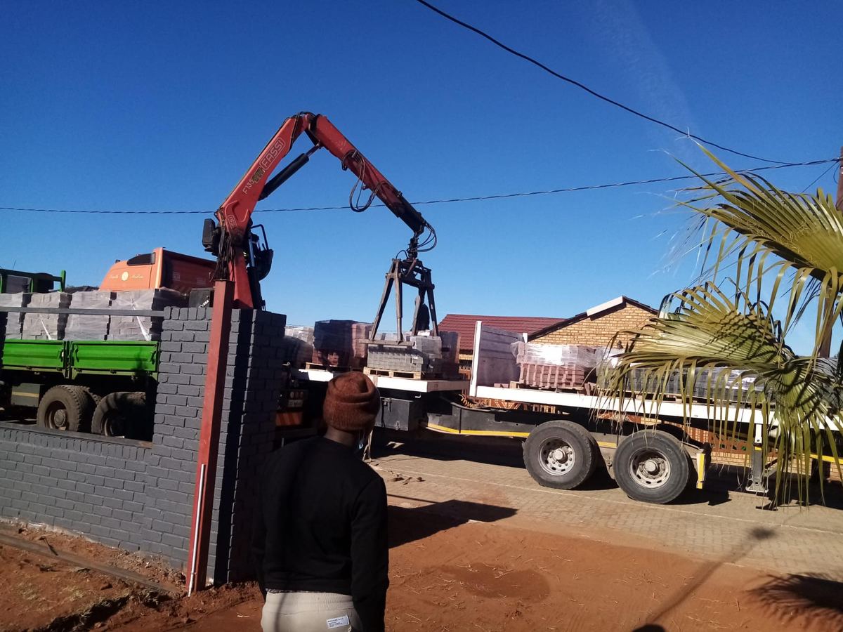 Crane truck delivering building materials to a project
